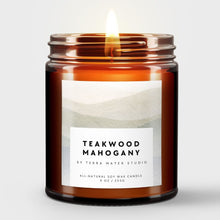 Load image into Gallery viewer, Scented candle in an amber jar labeled 'Teakwood Mahogany' by Terra Mater Studio on a white background
